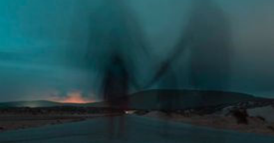 blurry shadow silhouettes hold hands on a road at dusk