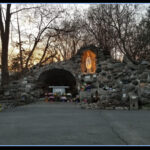 outdoor worship stone cave grotto with lit up saint in exterior wall