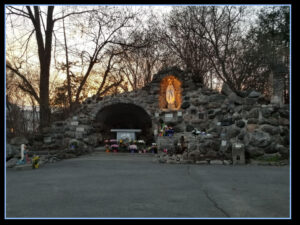outdoor worship stone cave grotto with lit up saint in exterior wall