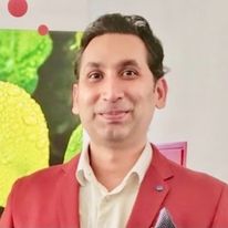 colourful portrait of Indian man in red tux smiling
