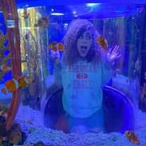 candid photo of woman in fishtanks acting surprised